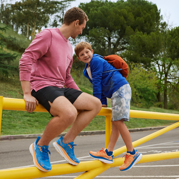 Man and child wearing HOKA shoes