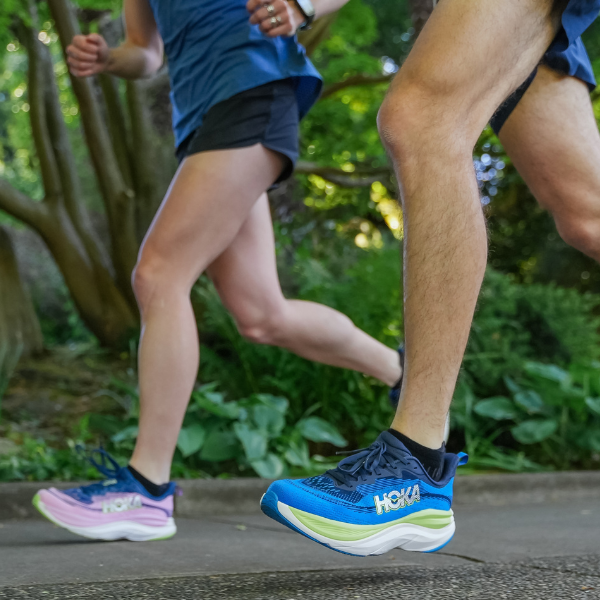 Man and woman wearing HOKA Skyflow shoes