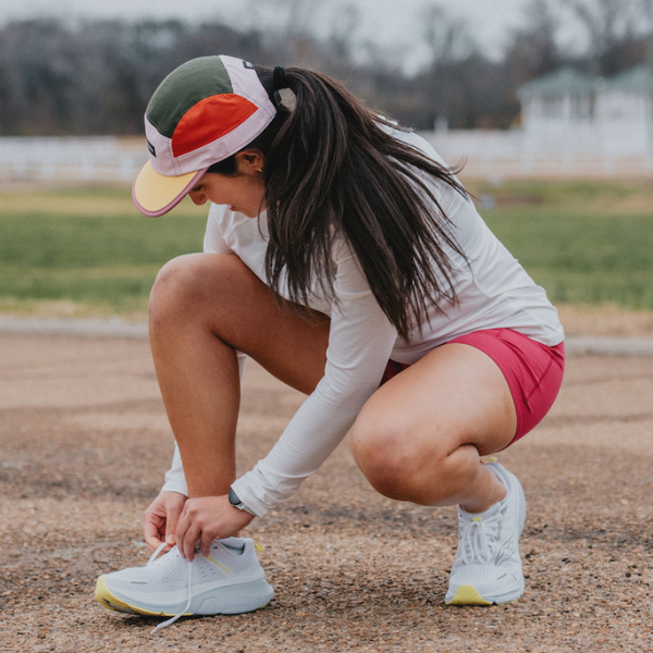 Woman tying Saucony shoes