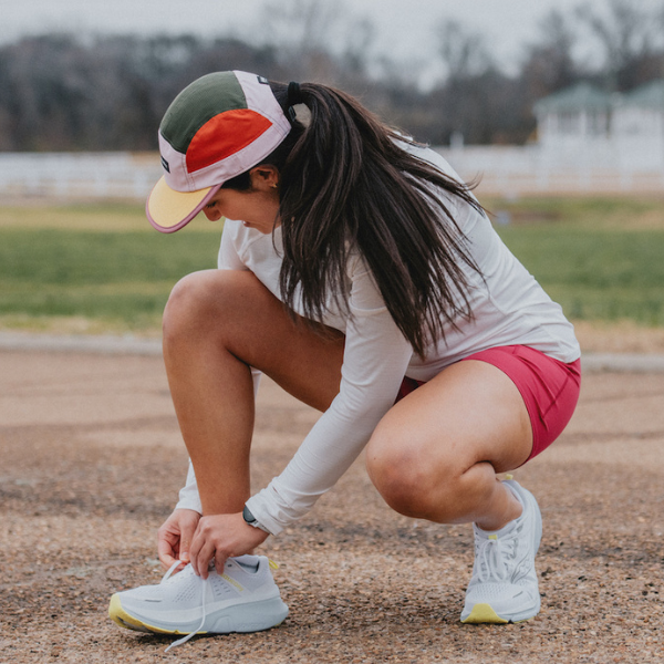 Woman tying Saucony shoes